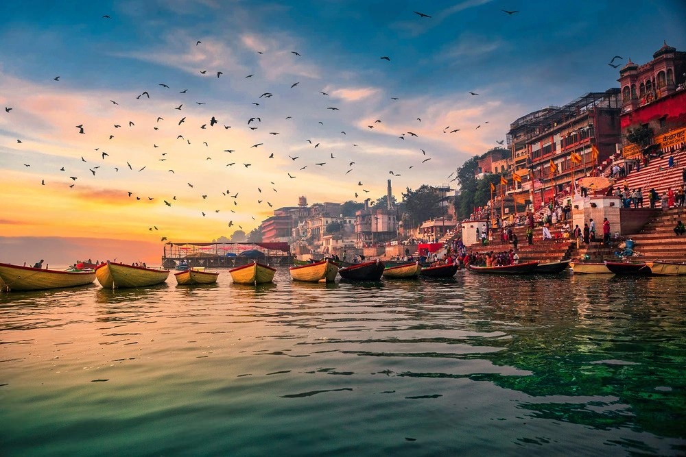 Varanasi travel guide sunrise view of Ganga river ghats with boats and morning rituals