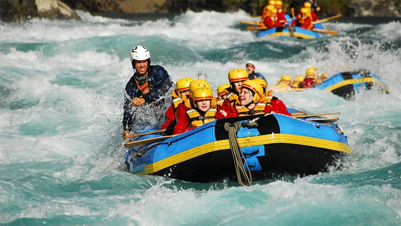 Group enjoying white water rafting in Rishikesh with strong river rapids